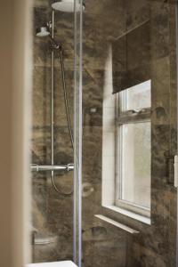 W łazience znajduje się prysznic ze szklanymi drzwiami. w obiekcie Nomi Rooms & Restaurant w mieście Bangor