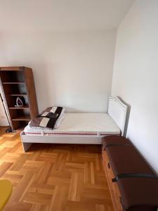 ポドゴリツァにあるApartman Zvjezdiceのベッド1台が備わるウッドフロアの小さな客室です。