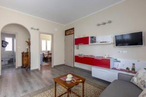 ein Wohnzimmer mit einem Sofa und einem TV an der Wand in der Unterkunft Casa Laura comodissima al centro e spiagge in Diano Marina