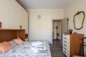 Schlafzimmer mit einem Bett, einer Kommode und einem Spiegel in der Unterkunft Casa Laura comodissima al centro e spiagge in Diano Marina