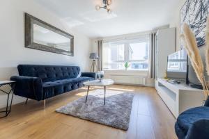 a living room with a blue couch and a table at Stunning City Centre 1 Bed with Free Parking in Glasgow