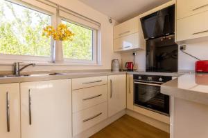 una cocina con armarios blancos y una ventana en Stunning City Centre 1 Bed with Free Parking en Glasgow