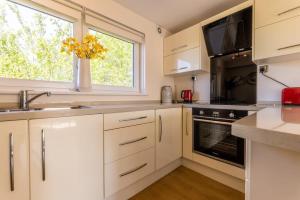 a kitchen with white cabinets and a window at Stunning City Centre 1 Bed with Free Parking in Glasgow
