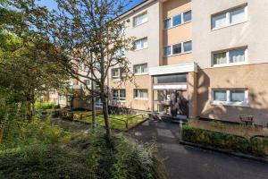 an apartment building with benches in front of it at Stunning City Centre 1 Bed with Free Parking in Glasgow