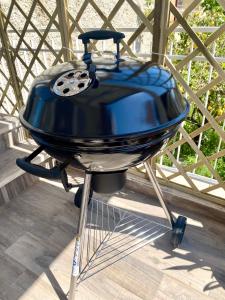 - un barbecue bleu installé au-dessus d'une terrasse couverte dans l'établissement Family House, à Santa Severa