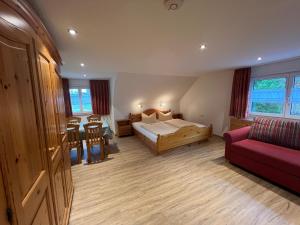 a bedroom with a bed and a couch and a table at Hotel Zum Löwen - Unteres Wirtshaus in Titisee-Neustadt