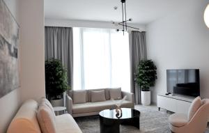 ドバイにあるSea Breeze Oasisのソファとテレビのあるリビングルーム