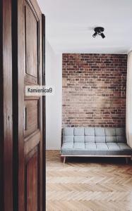 um quarto com um sofá contra uma parede de tijolos em Hostel Kamienica 9 em Sosnowiec