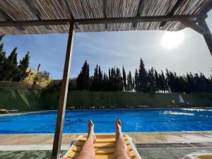 a person laying on a lounge chair next to a pool at La Casa del Carrer Major in Santa Magdalena de Pulpis