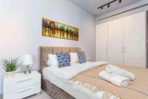 ein Schlafzimmer mit einem großen Bett und einem Gemälde an der Wand in der Unterkunft Livloft 2-BR in Mar Mikhael in Beirut