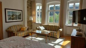 a bedroom with a bed and two chairs and a table at Villa Norma in Bad Schandau