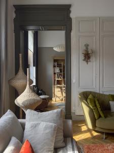 a living room with a couch and a mirror at La Maison Mulato in Libourne