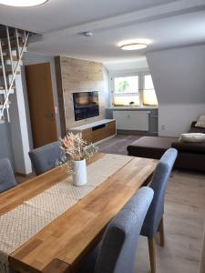 sala de estar con mesa de madera y sillas azules en fewo-friends, en Reinfeld