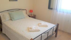a bedroom with a bed with two towels on it at Giannos Apartments in Agia Effimia