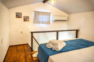 a bedroom with a bed with towels on it at Bangalô Arco Íris (Quadrado Trancoso) in Trancoso