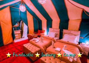 um quarto com 2 camas numa tenda em Fantastic Luxury Camp em Merzouga