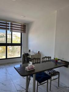 a living room with a table and chairs in it at Close to airport, Quick friendly stop in Amman