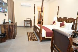 Ranthambore Tiger Inn Comfort Resort في ساواي مادهوبور: غرفة نوم مع سرير بأربعة أعمدة ومكتب