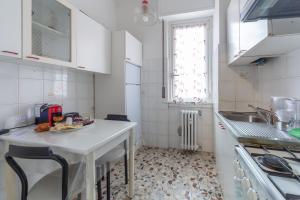 a white kitchen with a table and a sink at "Casa Zenit" 3 minuti Metro & 20 minuti Duomo di Milano in Sesto San Giovanni