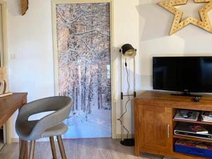 ein Wohnzimmer mit einem TV und einer Schiebetür in der Unterkunft Appartement Les Orres, 2 pièces, 6 personnes - FR-1-322-197 in Les Orres
