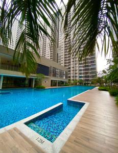 a swimming pool in front of a building with tall buildings at Youth City 2 Bedroom Pool View by DKAY in Nilai in Nilai