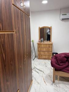 a room with a wooden cabinet and a mirror at Close to airport, Quick friendly stop in Amman