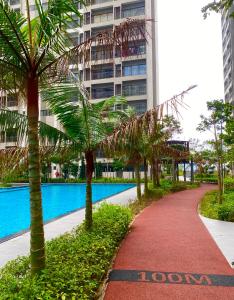 a pathway with palm trees in front of a building at Youth City 2 Bedroom Pool View by DKAY in Nilai in Nilai