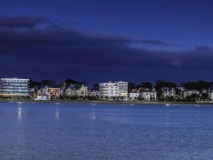 a view of a city from the water at night at Studio Royan, 1 pièce, 3 personnes - FR-1-494-61 in Royan