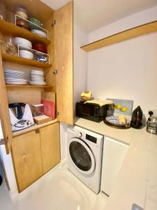 a kitchen with a washing machine in a kitchen at Urban Oasis Chic 1BR Flat with Spacious Garden in London