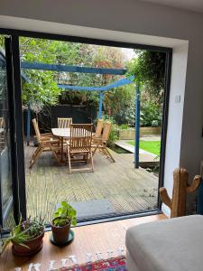 a patio with a table and chairs on a deck at Urban Oasis Chic 1BR Flat with Spacious Garden in London