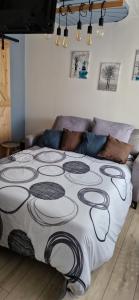 Una cama con una manta blanca y negra encima. en Némo Petit studio cosy., en Orville