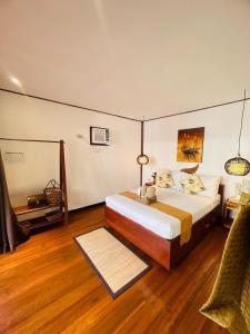 1 dormitorio con 1 cama y 1 silla en una habitación en Bella Athena Garden en El Nido