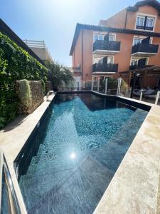 a swimming pool in front of a building at Logis Hotel De La Clape in Narbonne-Plage