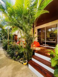 une maison avec des palmiers sur son côté dans l'établissement Bella Athena Garden, à El Nido