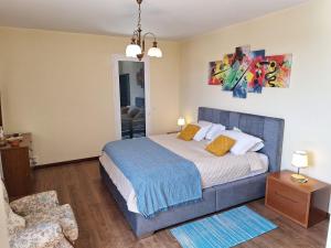 a bedroom with a large bed and a chair at Villa Familia Dehoux in Camacha