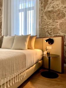 a bedroom with a bed with a table and a window at VISEU EXECUTIVE Hotel in Viseu