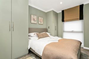um quarto com uma cama grande e uma janela em Luxurious & Spacious Townhouse em Londres