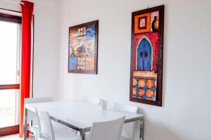 un comedor con una mesa blanca y una vidriera en Trilocale 37 Residence La Giungla, en Falerna