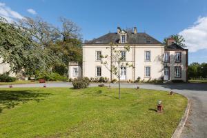 a large white house with a tree in the yard at Château de la Richerie - proche Puy du Fou in Beaurepaire