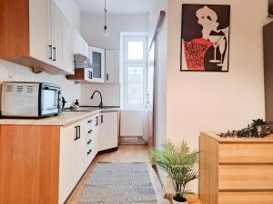 eine Küche mit weißen Schränken und einer Mikrowelle in der Unterkunft Beautiful and Spacious Apartment 69m2 for 5 guests next to Florian's Gate in Krakau