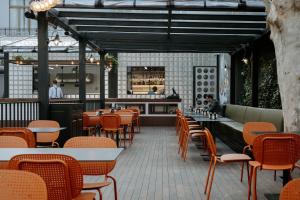 a restaurant with tables and chairs and a bar at Twenties Hotel in Tbilisi City