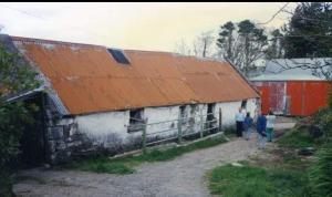 duas pessoas em frente a um prédio com um telhado laranja em The Old House at Belfield em Tralee