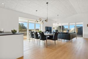 a dining room and living room with a table and chairs at Newly Built Luxury Holiday Home, Sensommervej 4 in Løkken