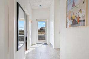 a hallway with white walls and a large painting on the wall at Newly Built Luxury Holiday Home, Sensommervej 4 in Løkken