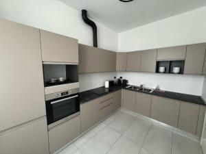a kitchen with white cabinets and black counter tops at Loft Azalea, by R Collection apartment in Como