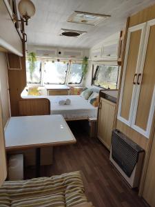 Una pequeña caravana con una cama y una mesa. en Yurta Bora Bora en L'Ametlla de Mar