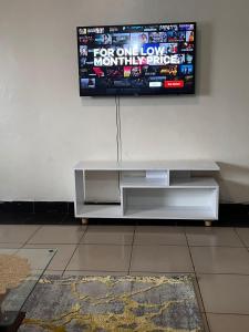 a television hanging on a wall in a living room at Klimax Homes in Kiambu