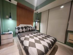 - une chambre avec un lit à damiers noir et blanc dans l'établissement Double Bed, White Sand, Gym, Wave Pool & More, à Manille