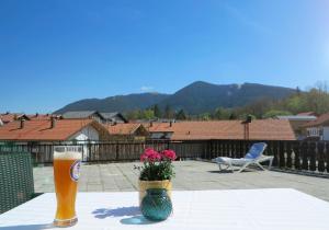 una mesa con un vaso de cerveza y un jarrón con flores en Hike 'n Bike Base, en Bad Kohlgrub