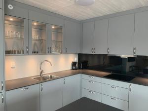 a kitchen with white cabinets and a sink at Folkestadvegen 23Q in Bø